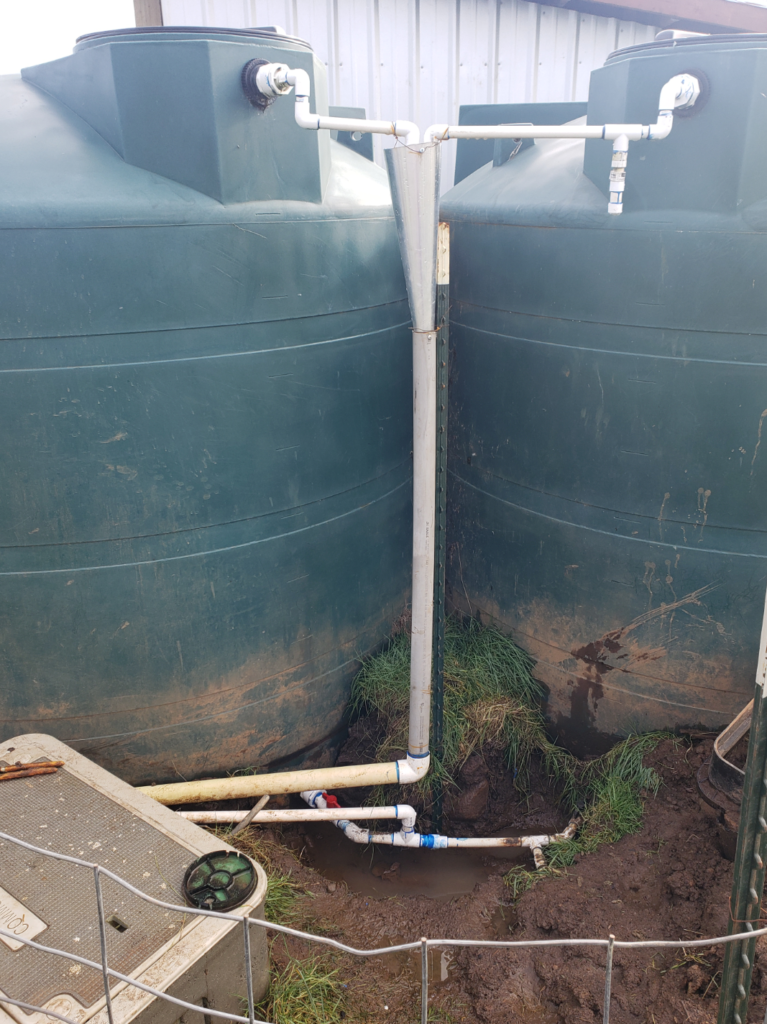 Water tanks hooked together and into pipe going north towards the house