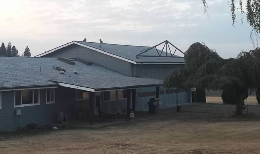 Exterior of house, showing BEFORE of hangar including truss on roof